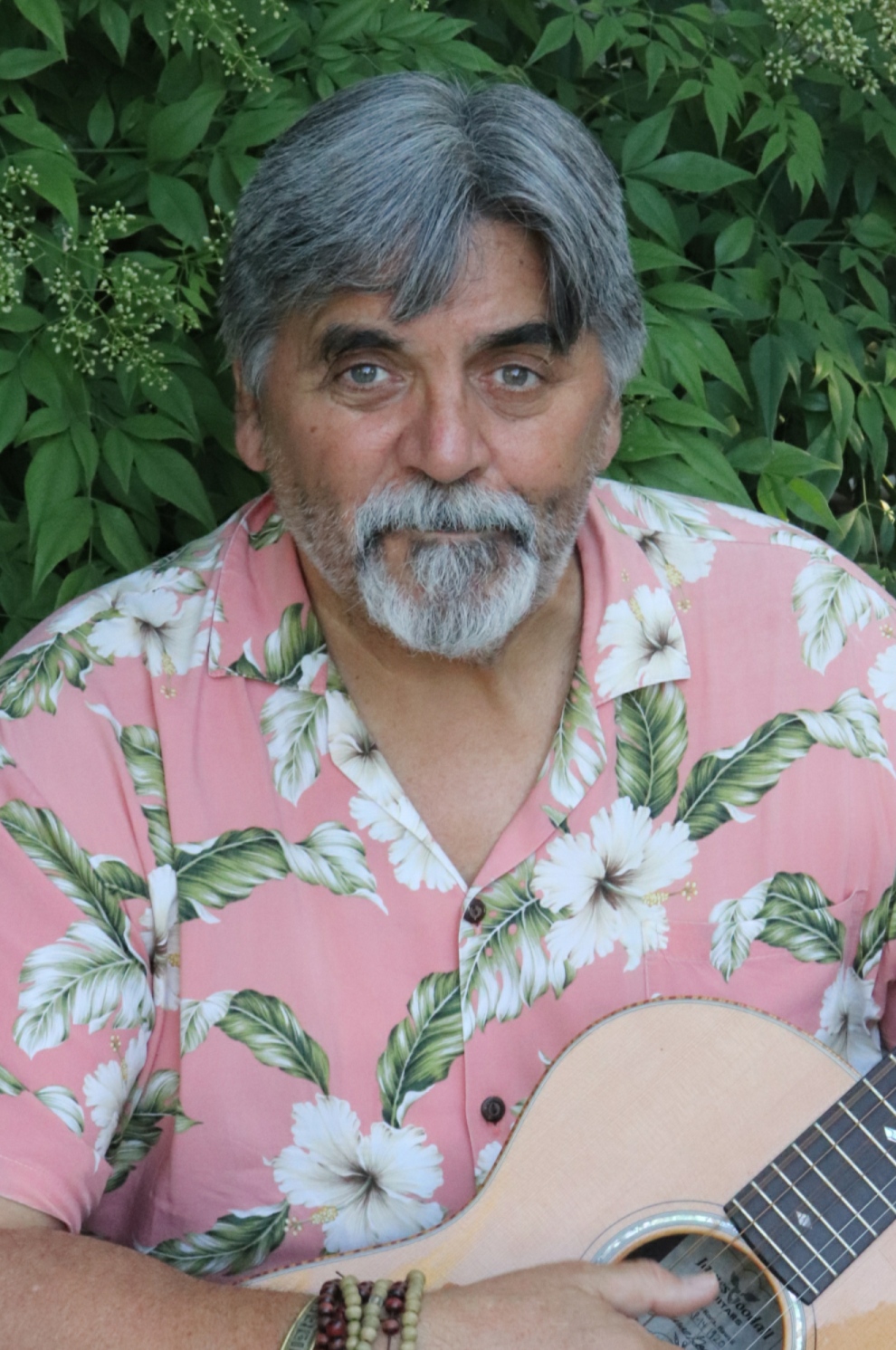 Markmin pink Hawaiian shirt holding guitar